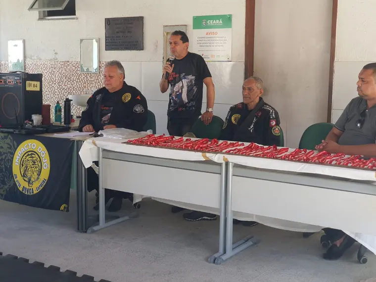 Mesa de abertura do evento com o diretor discursando ao microfone