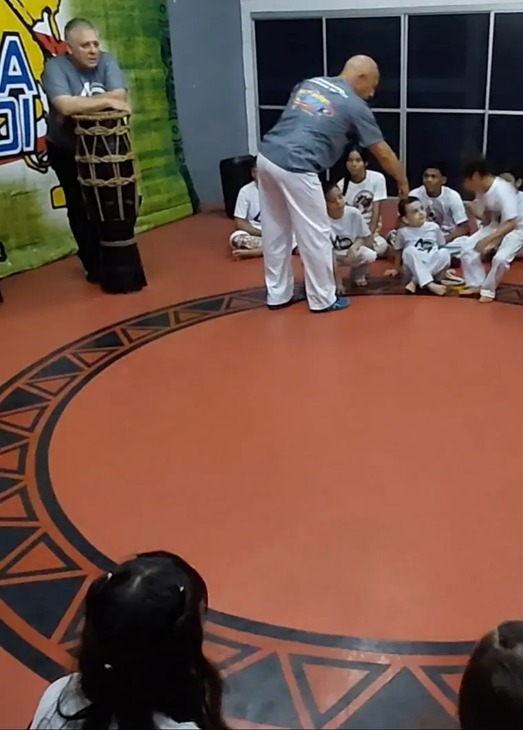 Mestre Dunga orientando alunos no centro da roda de capoeira