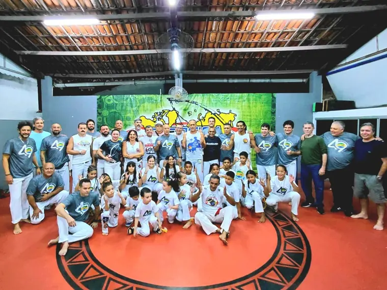 Grande equipe de alunos reunida no tatame verde do Impacto Dōjō