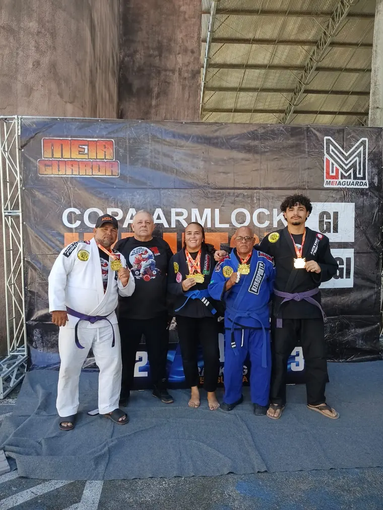 Grupo de atletas no pódio da Copa Armlock com medalhas