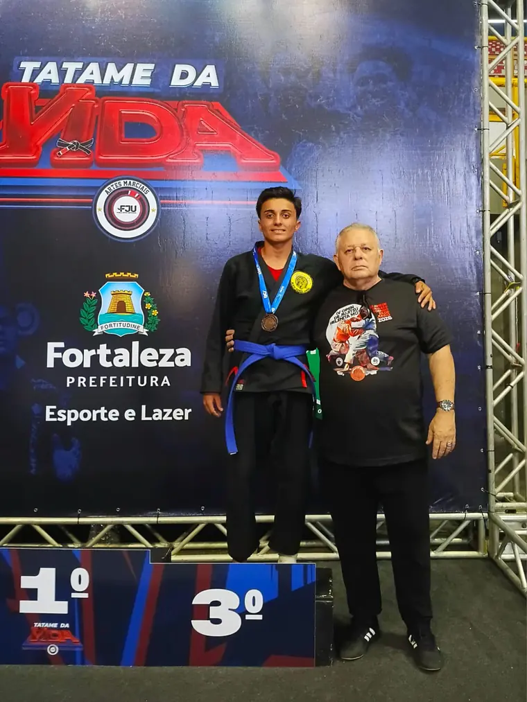 Aluno no topo do pódio do Tatame da Vida ao lado do Mestre Dunga