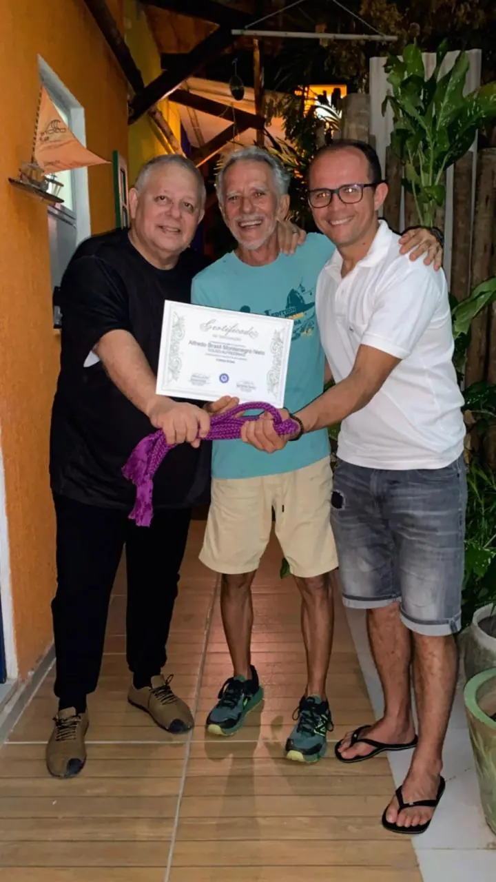 Mestre Dunga com dois amigos, exibindo um certificado