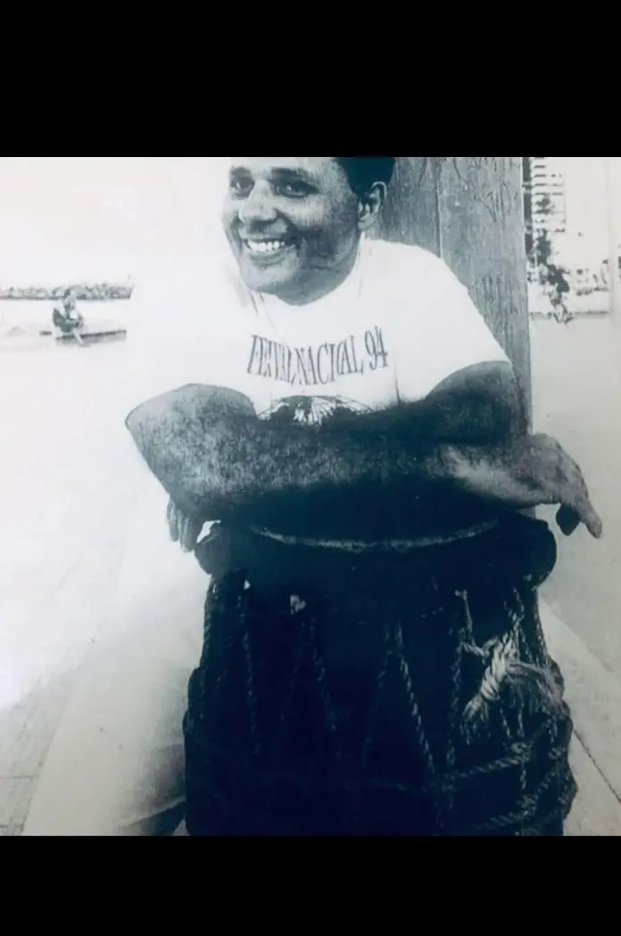 Fotografia antiga em preto e branco de um capoeirista com atabaque