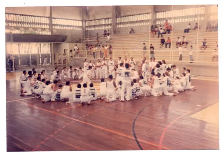 Capoeiristas reunidos em ginásio nos anos 90